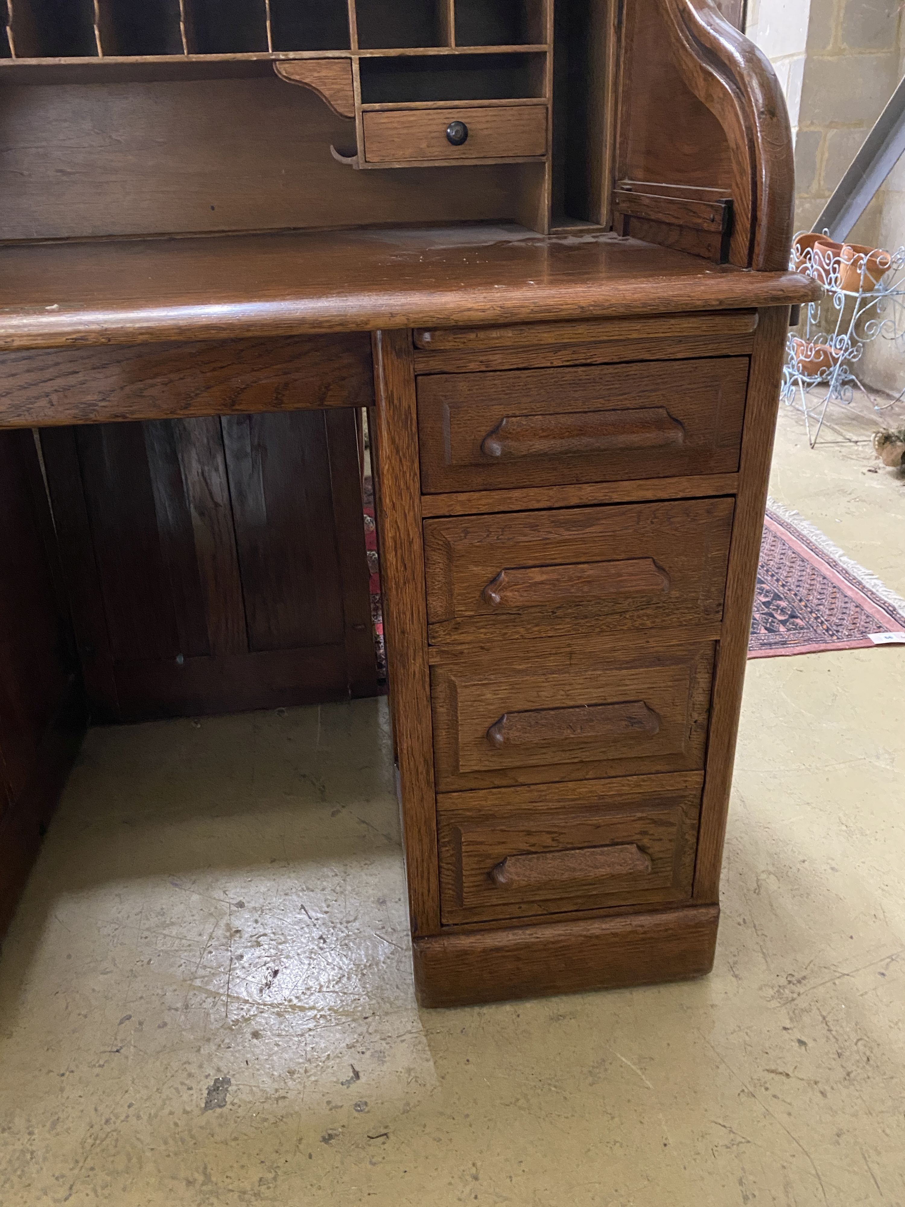 An early 20th century oak roll top desk with 'S' shaped tambour, width 122cm, depth 78cm, height 124cm